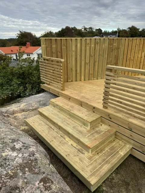 Trädäck med höga insynsskydd byggt direkt på berget
