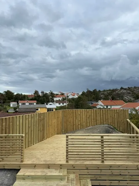 Trädäcket på berget med utsikt över husen nedanför