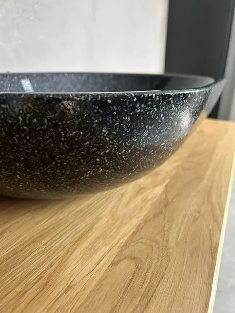 Närbild på tvättstället i svart terrazzo på ekskivan